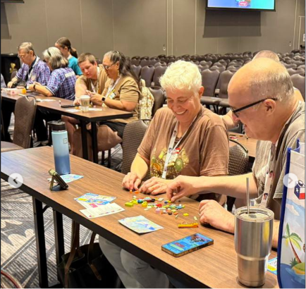Attendees at Brick Rodeo seated at long tables, sorting through colorful LEGO bricks and building their Fast Brix! creations together.