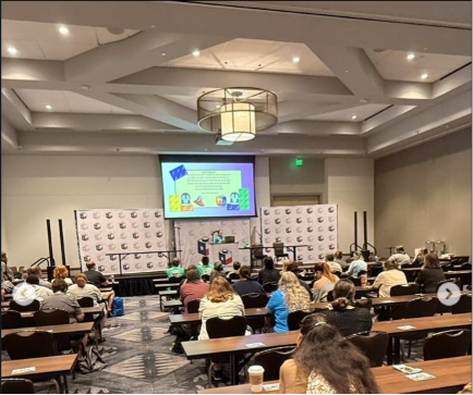 A full workshop room at Brick Rodeo with rows of attendees seated and facing a stage where Sloane is presenting Fast Brix!